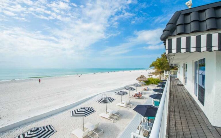 balcony view of beach with striped umbrellas at anna maria island inn bradenton beach