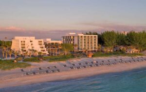 beachfront high rise hotel with loungers and sunset sky at zota beach resort longboat key