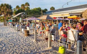 crowded beachfront dining area with string lights at anna maria island beach cafe