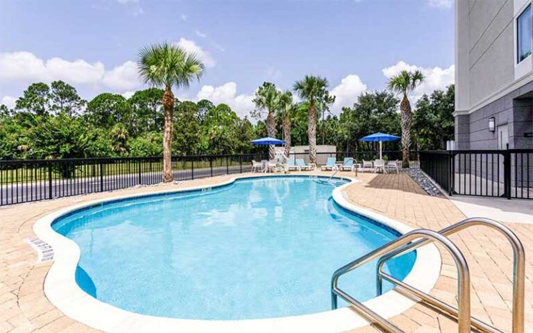 curvy shaped pool with loungers at hampton inn titusville