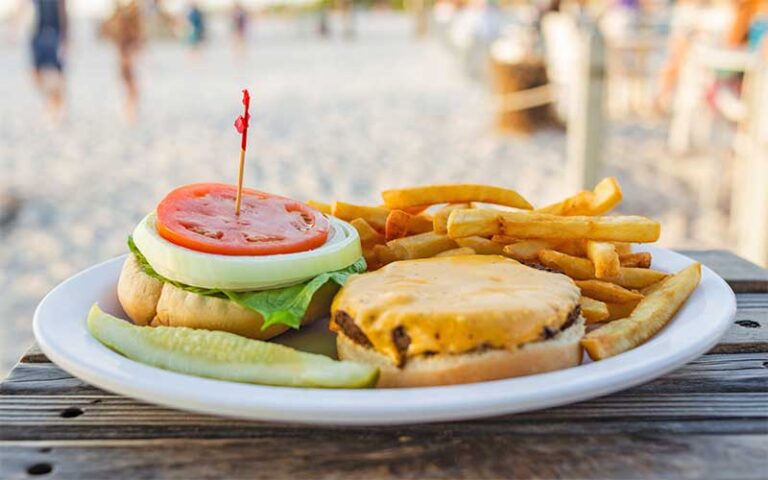 deluxe burger with fries on outdoor beach patio at anna maria island beach cafe