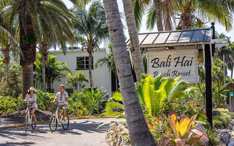 front exterior with sign and bicycling couple at bali hai beach resort holmes anna maria island