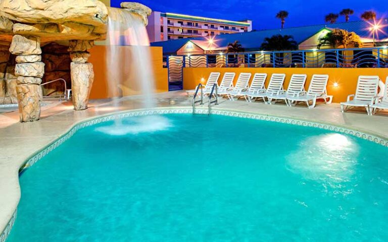 lighted pool with water feature at night at four points by sheraton cocoa beach