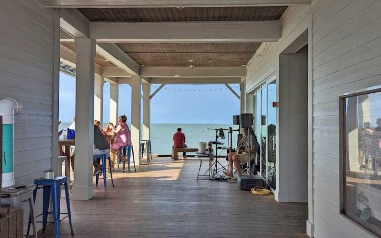 outer patio of building over ocean with diners at anna maria city pier island