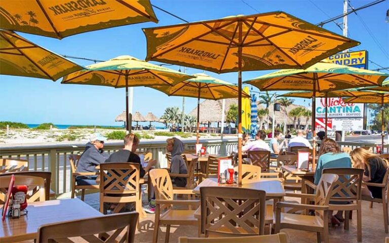 patio dining area with umbrellas and beach view at wicked cantina bradenton beach anna maria island