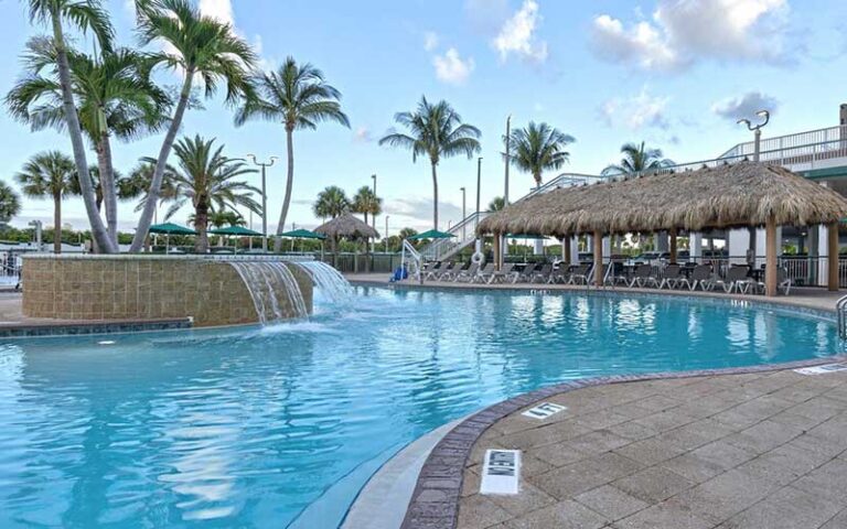 pool with tiki huts and waterfall at the resort on cocoa beach