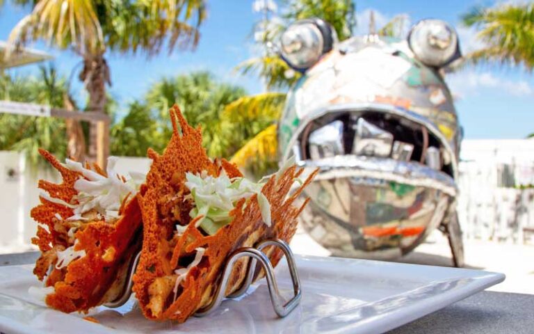 signature grouper tacos in outdoor patio with fish sculpture at the ugly grouper holmes beach anna maria island