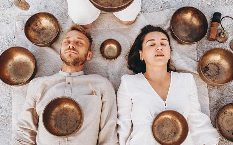 man and woman lying side by side with tibetan bowls meditating at zillian holistic wellness orlando kissimmee