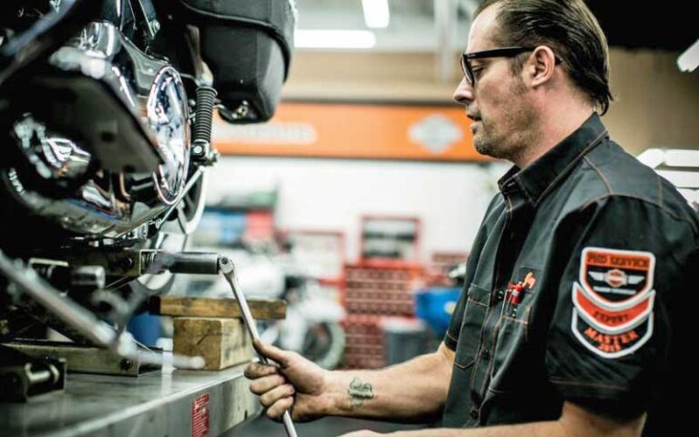 mechanic working on lifted motorcycle in garage at petersons harley davidson miami